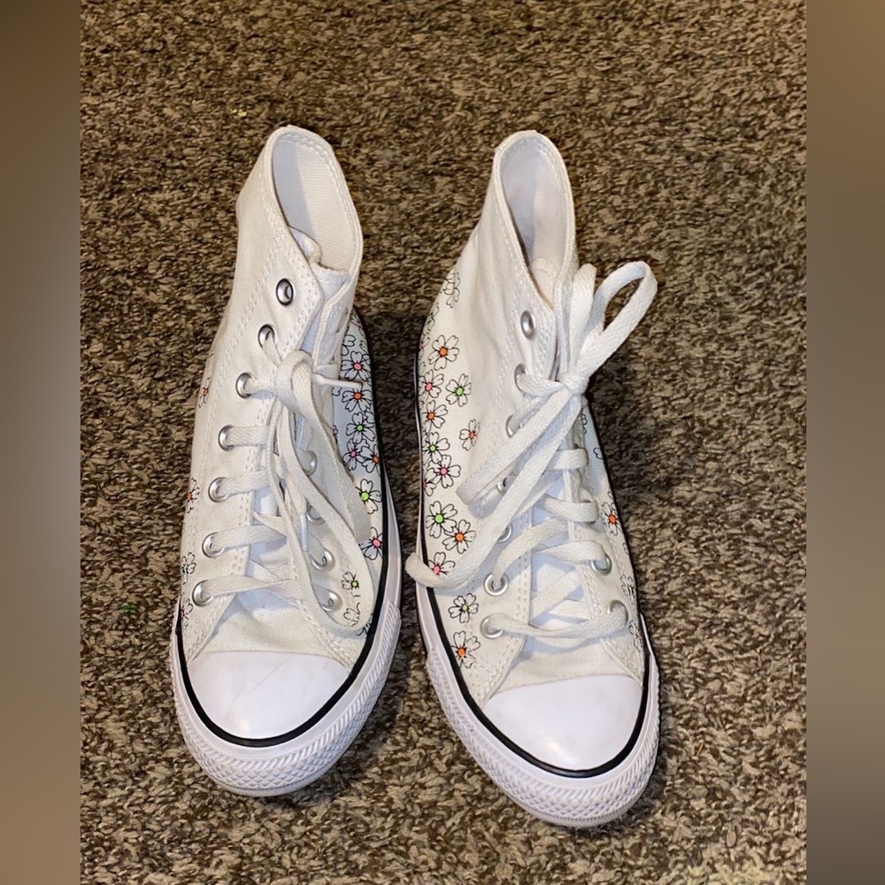 White Chuck Taylor converse for sale with flowers on the bottom.